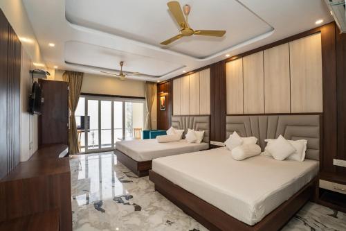 a bedroom with two beds and a ceiling fan at Coral Beach Resort Mandarmoni in Mandarmoni
