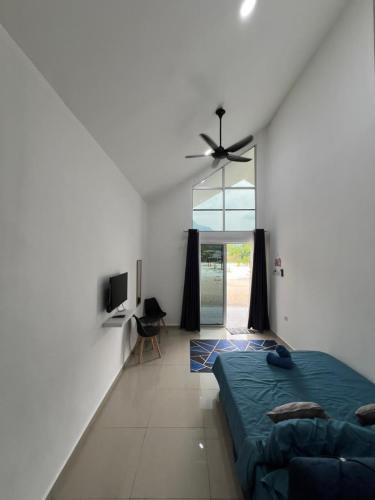 a bedroom with a bed and a ceiling fan at Gopeng Tiny House CUCHU in Gopeng