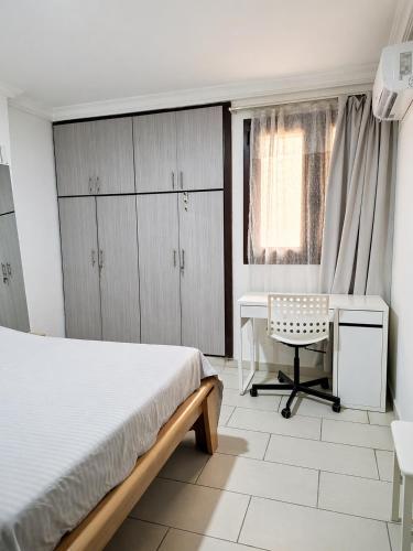 a bedroom with a bed and a desk and a chair at Monica Place in Abidjan