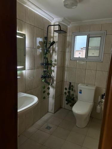 a bathroom with a toilet and a tub and a sink at Appartement cozy Bonamoussadi, WIFI & Goupe électrogène in Douala