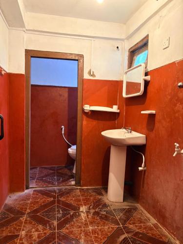 a bathroom with a toilet and a sink at Hiker's Hub in Maskeliya