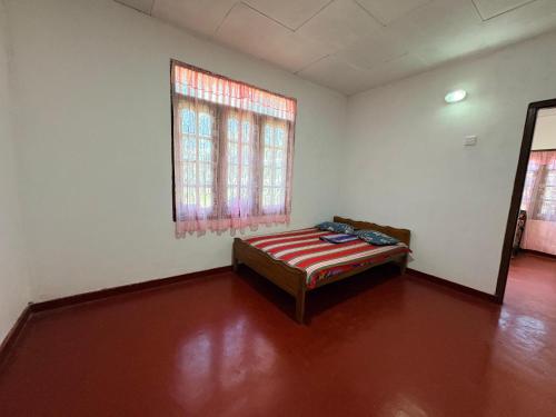 a room with a bed and a window in it at Hiker's Hub in Maskeliya