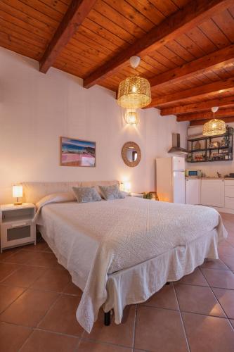 a bedroom with a large white bed with wooden ceilings at Le Gioie di Laura in Su Forti
