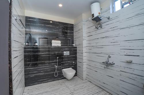 a bathroom with a shower and a toilet in it at Coral Beach Resort Mandarmoni in Mandarmoni