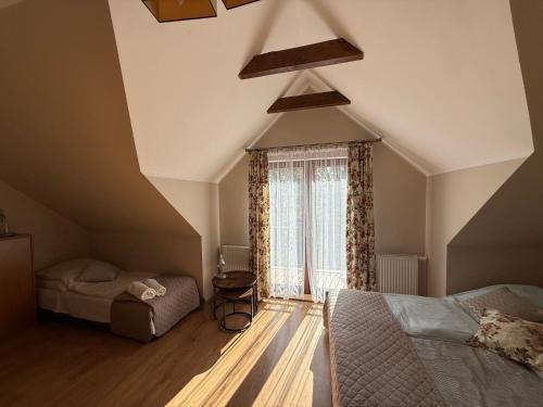 a attic room with two beds and a window at Dom nad jeziorem Mazury pomost segment 2 in Giżycko