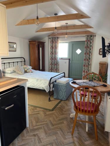 a bedroom with a bed and a table and chairs at Mini Treacle Cottage in Dundry
