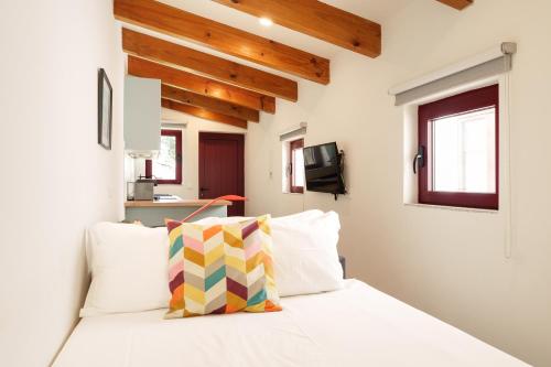 a bedroom with a white bed with wooden ceilings at VIVA Serralves Vintage House in Porto