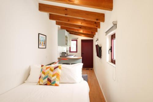 a bedroom with a white bed and wooden ceilings at VIVA Serralves Vintage House in Porto