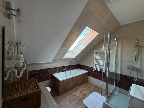 a attic bathroom with a bath tub and a window at Dom nad jeziorem Mazury pomost segment 2 in Giżycko