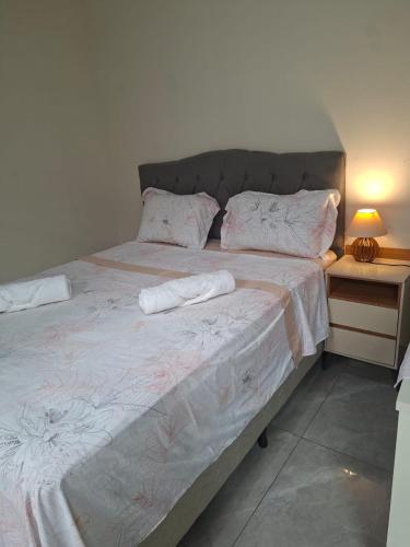 a bedroom with a large bed with two towels on it at Hosting Altos da cidade perto de tudo in Bauru