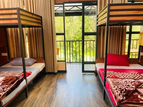 a bedroom with two bunk beds and a balcony at King Fern Cottage in Nuwara Eliya
