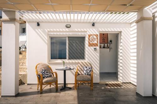a patio with two chairs and a table at Vrachos Nature Lodges PRINOS 3, Private pool in Agia Galini