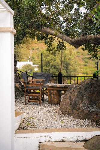 a picnic table and a bench under a tree at Vrachos Nature Lodges PRINOS 3, Private pool in Agia Galini