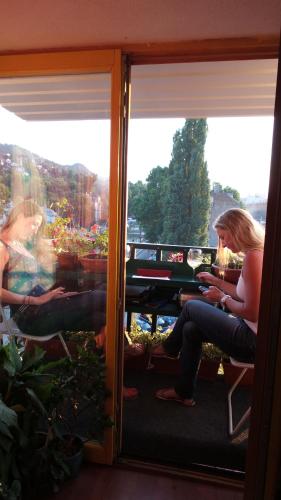 two women sitting in a room looking out the window at Apartments Emily in Sarajevo