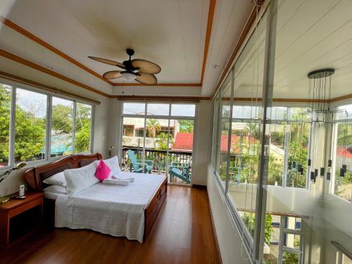 a bedroom with a bed and a ceiling fan at KRUEGERs Cottage in Sipalay