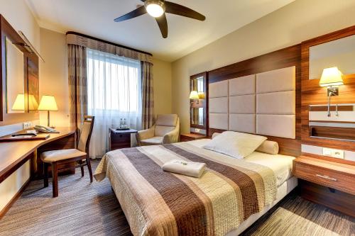 una camera d'albergo con letto, scrivania e sedia di Amber Hotel a Danzica