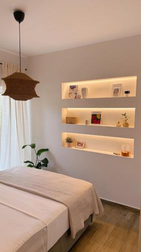 a bedroom with white shelves and a bed at Tashó Simply Living in Xylokastro