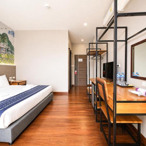 a bedroom with a bed and a desk with a computer at The Riva Vientiane Hotel in Vientiane