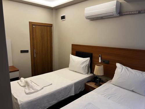 a hotel room with two beds and a fan at Hotel Bergama in Istanbul