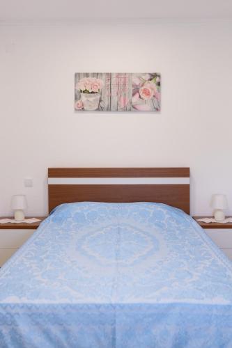 a bed with a blue comforter in a bedroom at Encosta da Cabreira in Vieira do Minho
