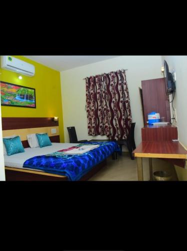 a bedroom with a bed and a desk and a window at Hotel Matheran Gaurav Cottage in Matheran