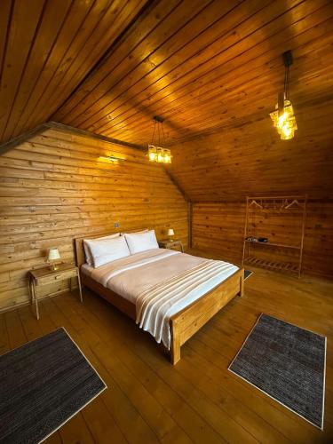 a bedroom with a bed in a wooden room at Ağaran Duru Konak Suit Bungalov in Rize