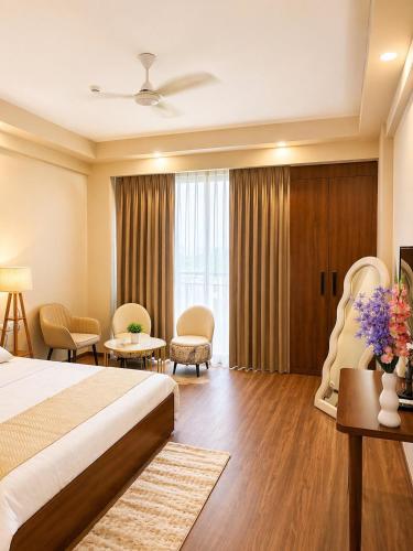 a hotel room with a bed and a large window at Veloria Grand Suites in Greater Noida