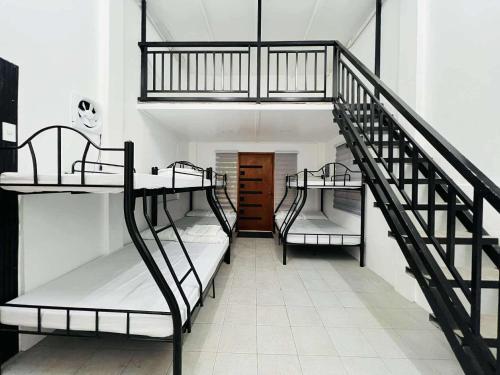 three bunk beds in a room with a staircase at Starksway Resort in Calubcub Primero