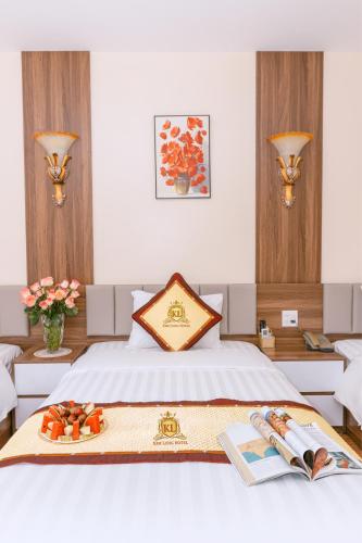 a bedroom with a bed with a tray of fruit on it at Kim Long Hotel Lao Cai - Near Hekou Border Gate in Lao Cai