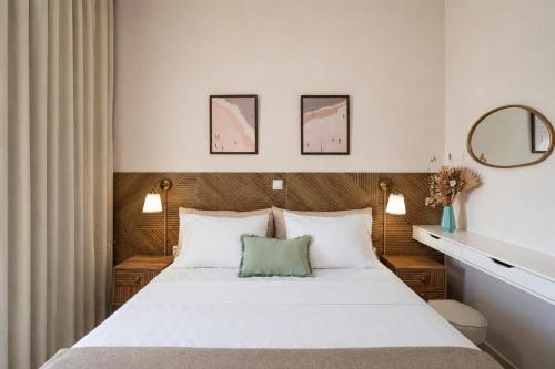 a bedroom with a white bed with a green pillow at Mesogitonia House in Zekros