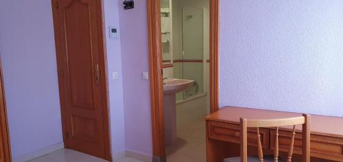 a bathroom with a sink and a table and a mirror at Hostal Restaurante Carolina in Pedrosillo el Ralo