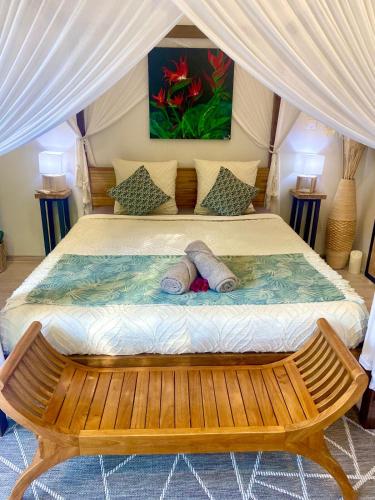 a bed in a tent with two pillows on it at Moderne Lodge Tropical in Les Abymes