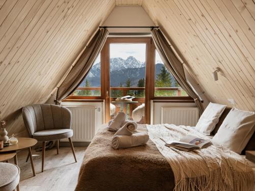 a bedroom with a bed and a large window at Willa Baciarka-widok, basen, sauna, jacuzzi in Kościelisko