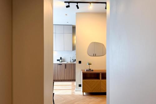 a kitchen with white cabinets and a wooden floor at NIDO Park view in Daugavpils