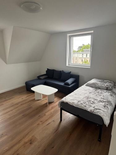 a room with a bed and a couch and a table at Erics Gästehaus in Uetersen