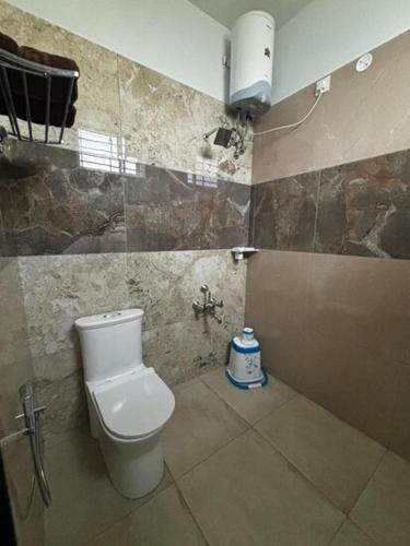 a bathroom with a white toilet in a room at Richmount Natural Resort Pvt Ltd in Yercaud