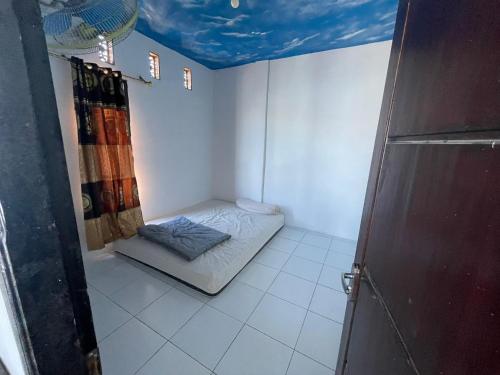 a small room with a bed in the corner of a room at Rusde's Komodo Homestay in Pulau Komodo
