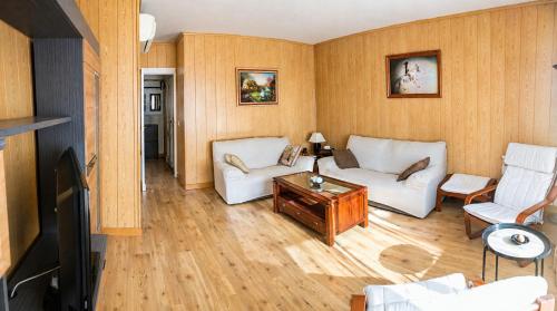 a living room with two white couches and a table at Piso de Verano en El Tiemblo in El Tiemblo