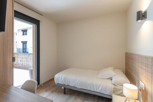 a small bedroom with a bed and a table at Be1960 segon in Bagá