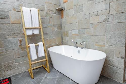 a bathroom with a white tub and a towel rack at Zondela House in Nkoanrua