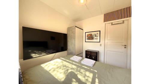 a bedroom with a bed with two towels on it at Cozy Room in the heart of Rødby! 5km from Femern & Puttgarden! in Rødby