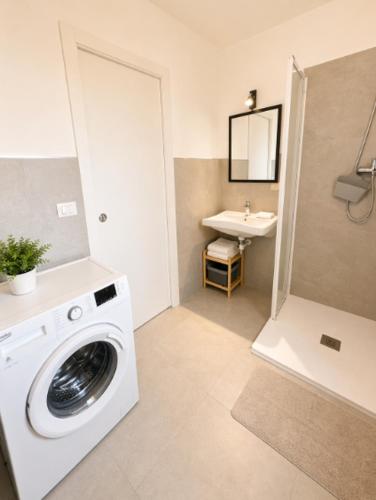a washing machine in a bathroom with a sink at RESIDENCE PACE - Agenzia Cocal in Caorle