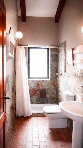 a bathroom with a tub and a toilet and a sink at Casa Pirinea, Maello, Avila in Maello