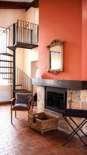 a living room with a fireplace and a mirror at Casa Pirinea, Maello, Avila in Maello