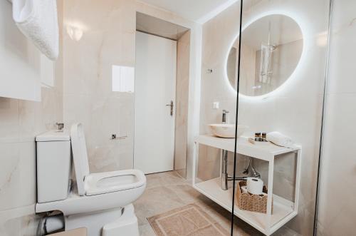 a white bathroom with a toilet and a glass shower at Liopetro in Sitia