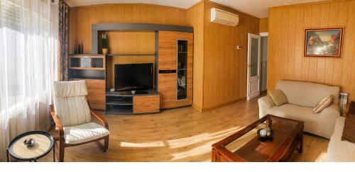 a living room with a couch and a tv at Piso de Verano en El Tiemblo in El Tiemblo