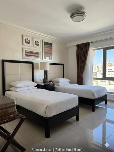 a hotel room with two beds and a window at Le Vendome Hotel in Amman