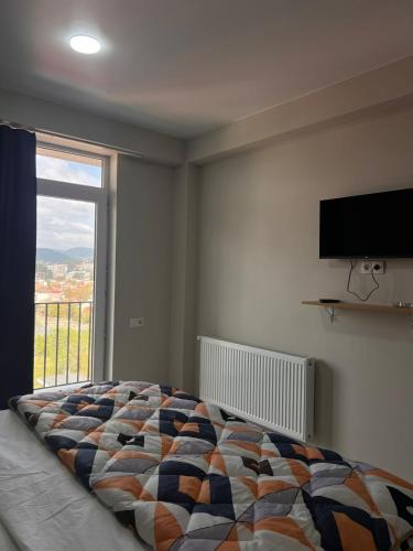 a bedroom with a bed and a large window at Comfortable 5 rooms apartment in Kutaisi