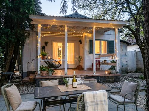 a patio with a table and chairs and a house at Bánhiday M4 Weekendhouse in Balatonakarattya