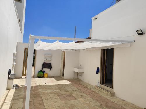 a white patio with a white canopy on a building at Casa Vacanze da Lui' in Torre Lapillo